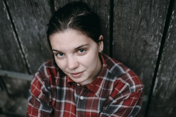 Smiling Caucasian woman leaning on wooden door