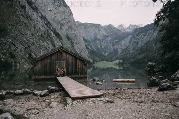 Caucasian couple sitting on dock at remote cabin