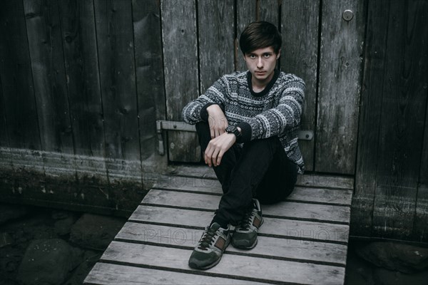 Caucasian man sitting on wooden dock