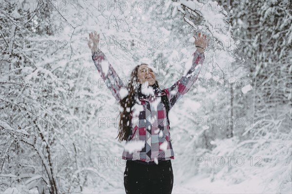Snow falling on Caucasian woman in forest