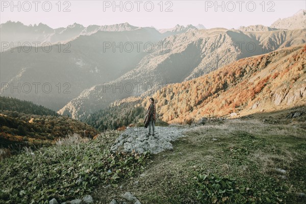 Caucasian woman smiling on mountain overlooking valley