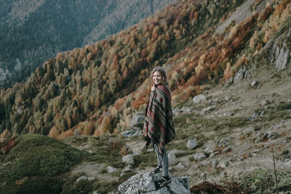 Caucasian woman smiling on mountain overlooking valley