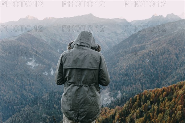 Caucasian man wearing coat looking at valley