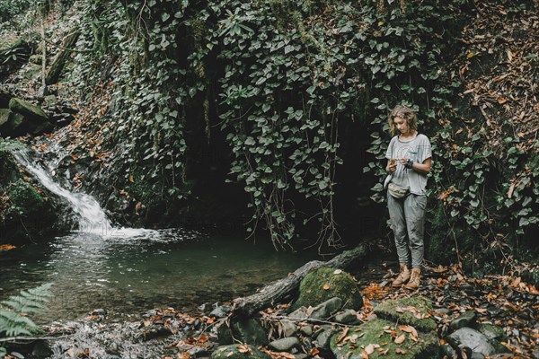 Caucasian woman standing near forest stream