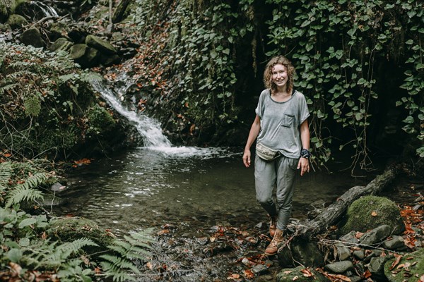 Caucasian woman standing near forest stream