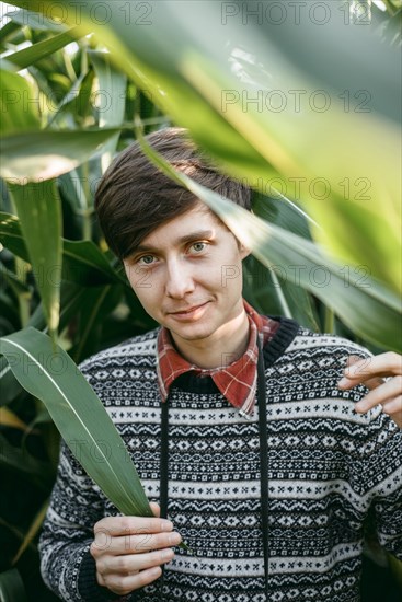 Caucasian man smiling in foliage