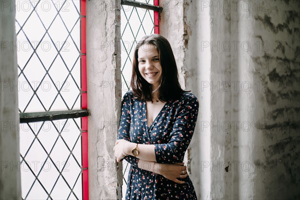 Portrait of smiling Caucasian woman standing near window