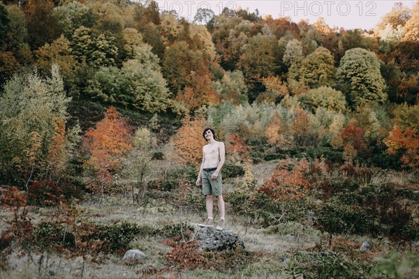 Caucasian man standing on rock in autumn