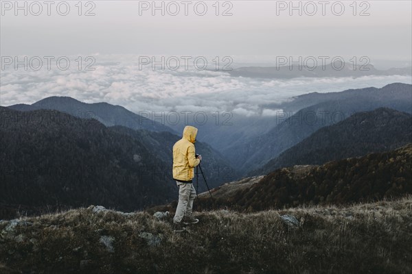 Caucasian man photographing in remote mountain landscape