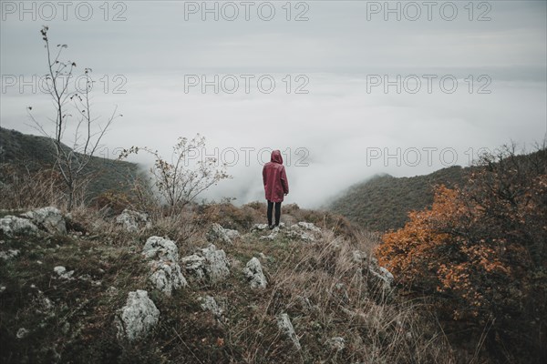 Distant Caucasian woman watching fog on ocean