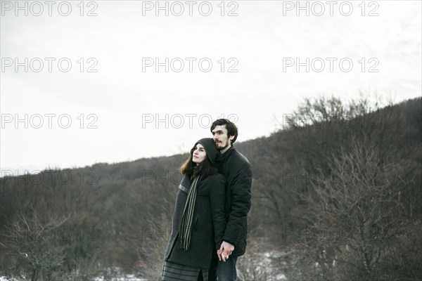 Caucasian couple standing on hill and relaxing