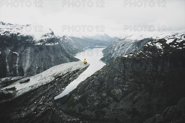 Caucasian man on cliff admiring scenic view of mountain river