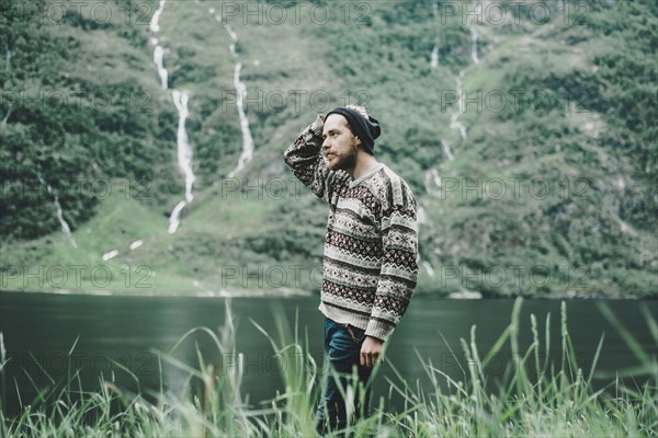 Pensive Caucasian man standing near river