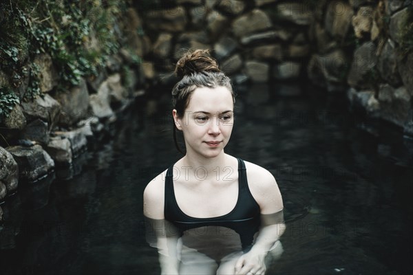 Caucasian woman swimming in pond