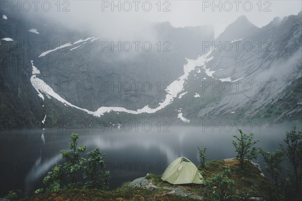 Camping tent near river in fog