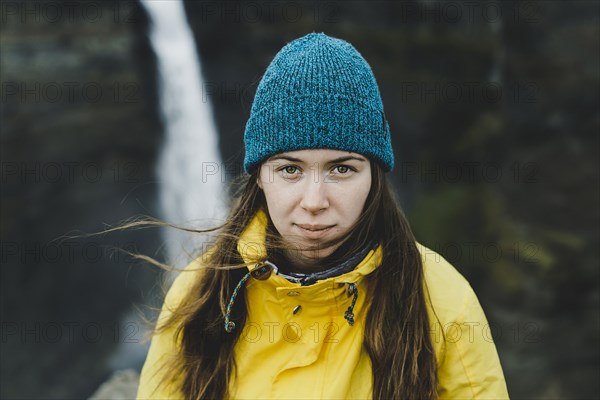 Wind blowing hair of Caucasian woman near waterfall