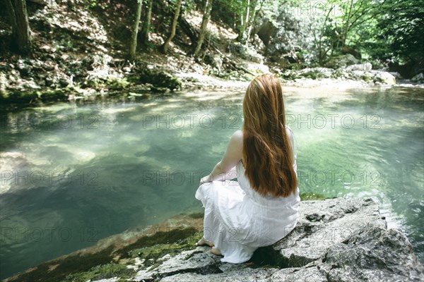 Caucasian woman sitting near river