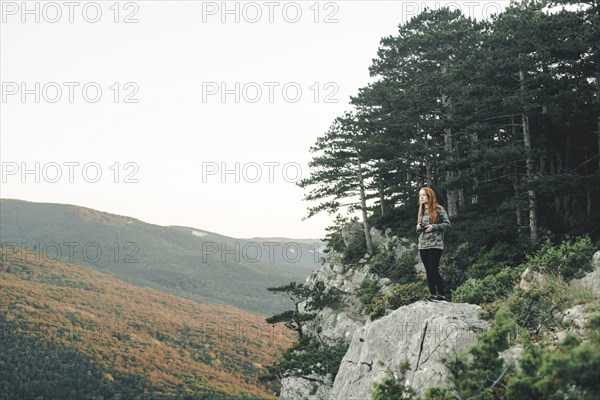 Caucasian woman standing on rock admiring scenic view of landscape