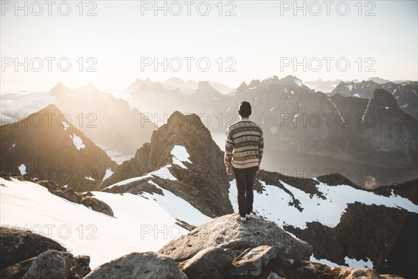 Caucasian man standing on rock admiring scenic view of mountain lake