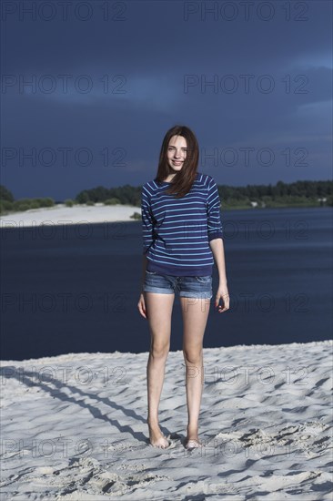 Caucasian teenage girl standing on beach