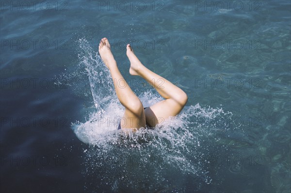 Caucasian teenage girl diving into water