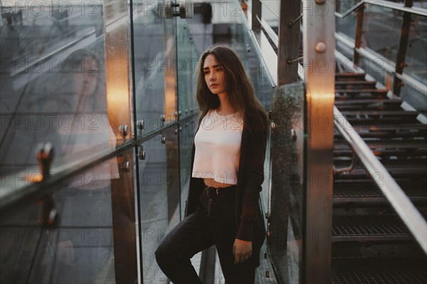 Pensive Caucasian woman at window near staircase