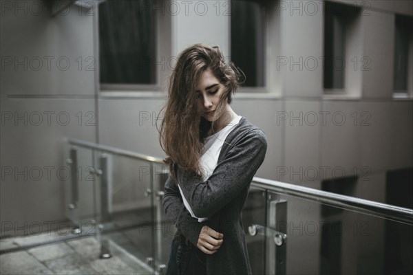 Pensive Caucasian woman standing near railing