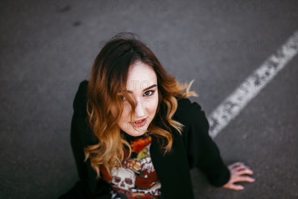 Caucasian woman sitting on street