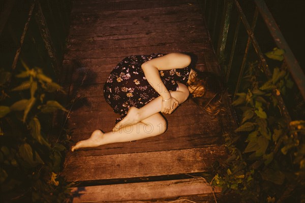 Caucasian woman laying on wooden bridge