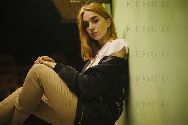 Pensive Caucasian woman leaning against wall