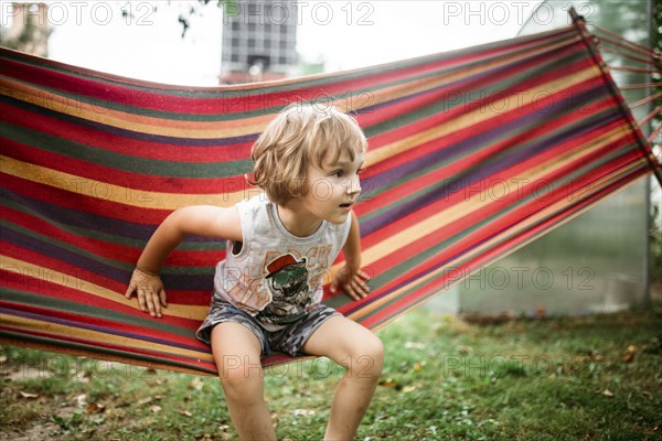 Caucasian boy sitting in hammock