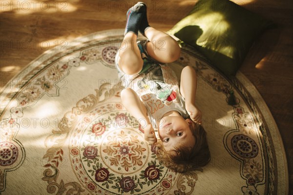 Caucasian boy laying on rug