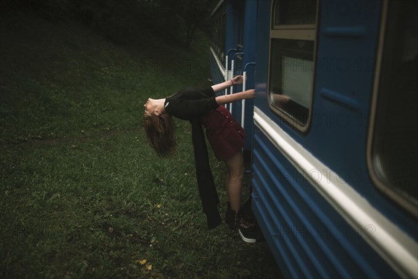 Caucasian woman hanging on train