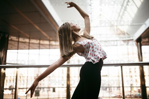 Caucasian woman dancing near railing