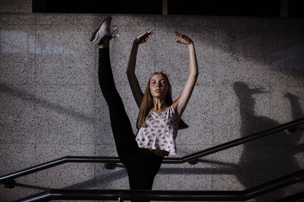 Caucasian woman dancing near staircase railing