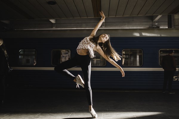 Caucasian woman dancing near train