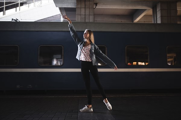 Caucasian woman dancing near train