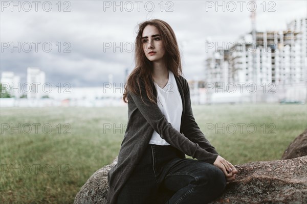 Caucasian woman sitting on rock