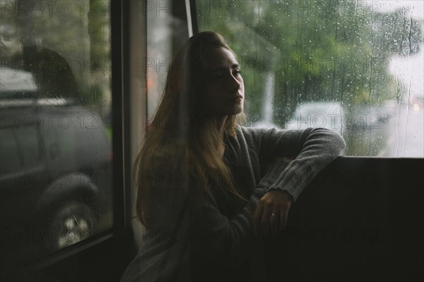 Pensive Caucasian woman sitting on bus in rain