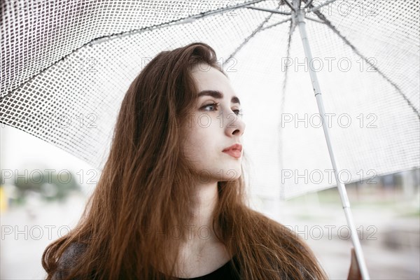 Caucasian woman holding white umbrella