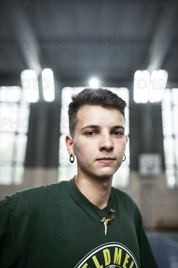 Portrait of serious Caucasian man wearing necklace and earrings