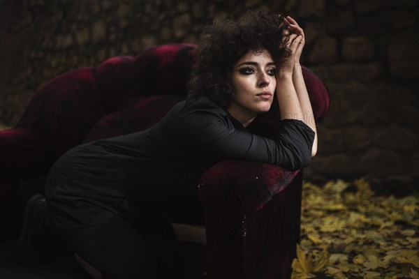 Pensive Caucasian woman laying on sofa outdoors