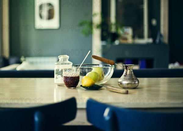 Bowl of fruit with jam and sugar on table