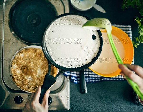 Woman making pancakes in kitchen