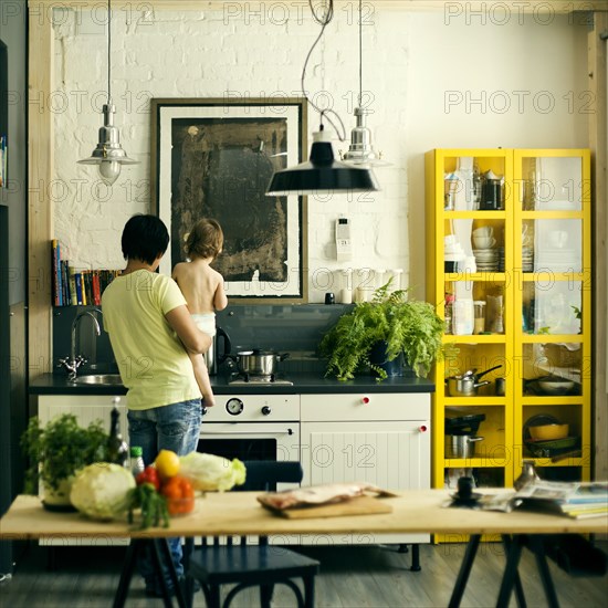 Mari father holding son in kitchen