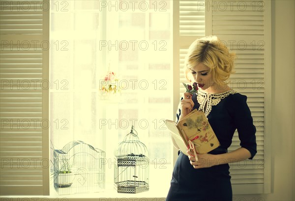 Caucasian woman reading by window