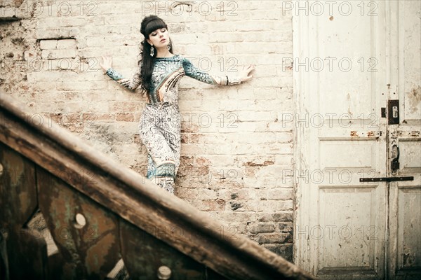 Caucasian woman standing on staircase in dilapidated house