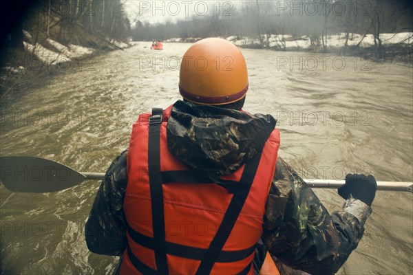 Mari man kayaking on snowy river