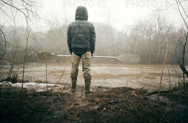 Mari man holding paddle by snowy river