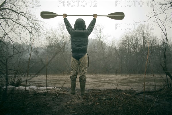 Mari man holding paddle by snowy river